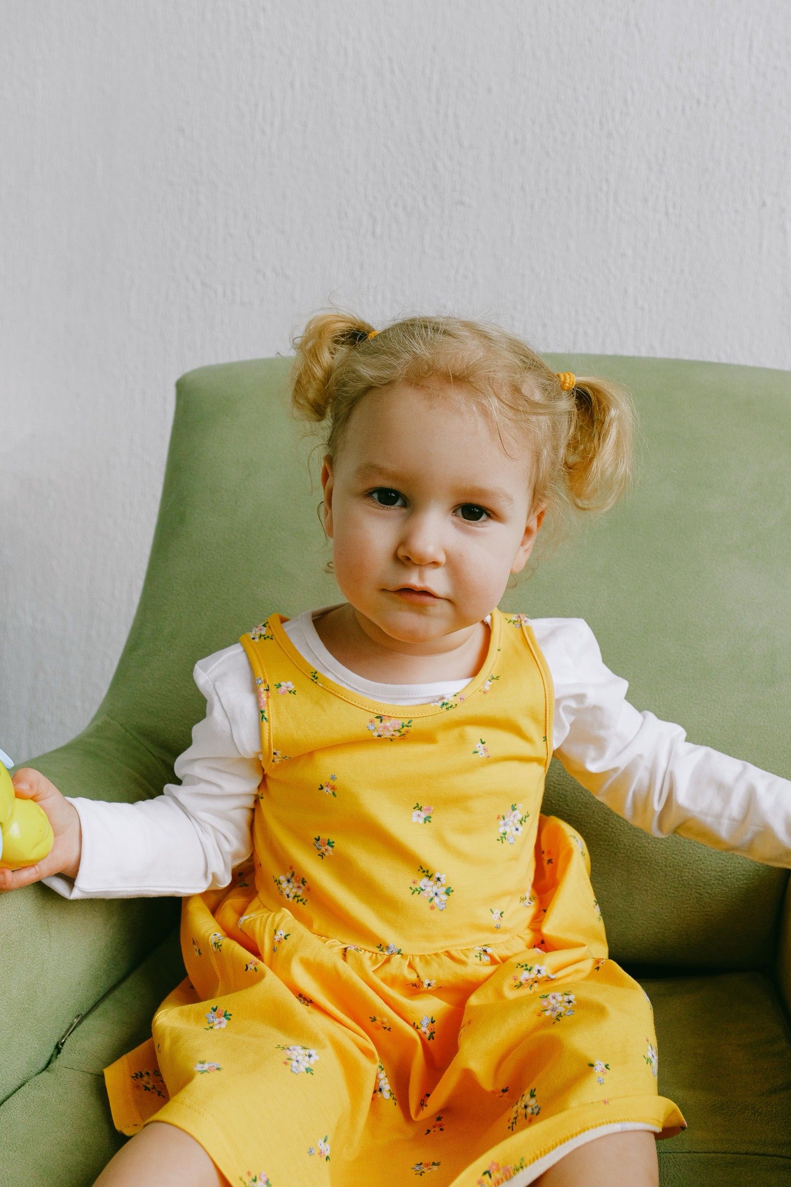 A young child sitting in a green armchair