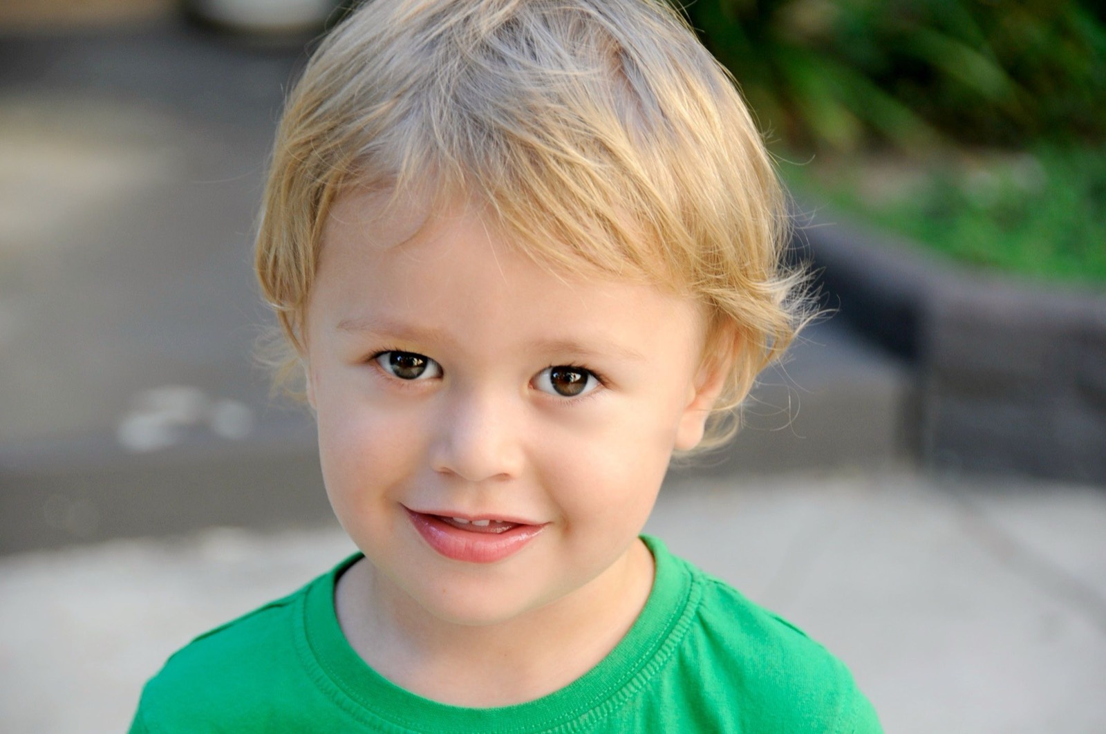 A young child smiling outdoors